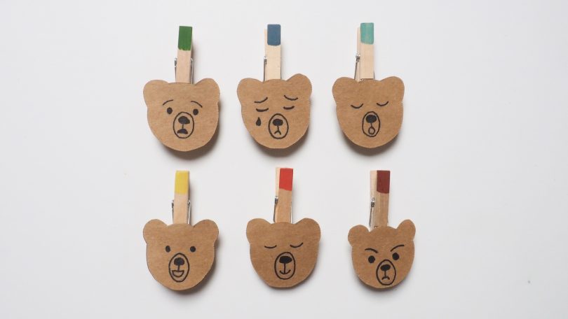 Collage des pinces sur les têtes des oursons qui représentent les émotions.