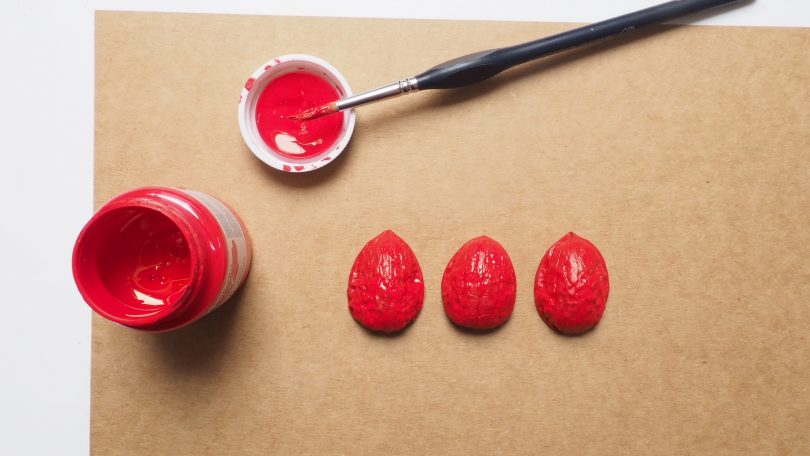 Peindre trois coques de noix en rouge