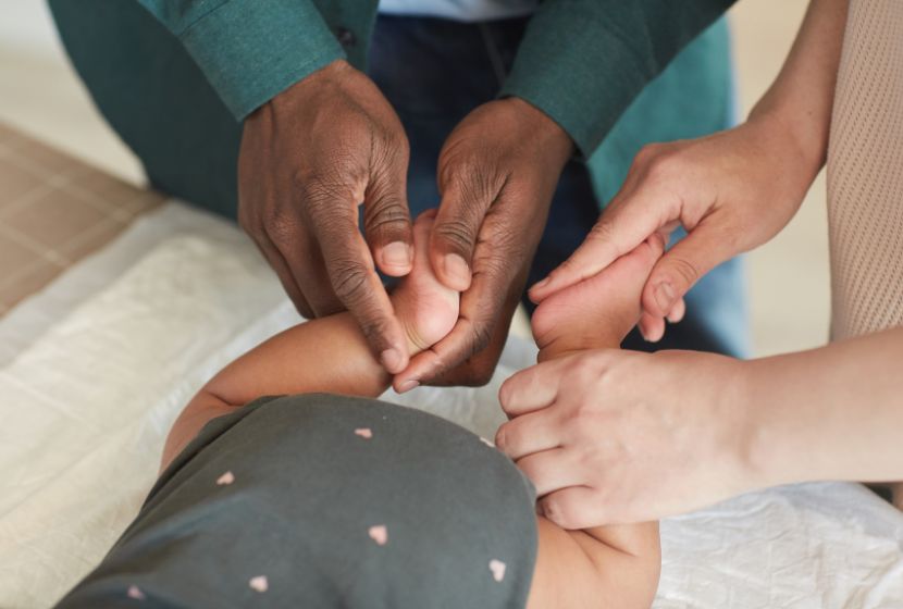 Parents qui s'initient au massage bébé sur leur tout-petit.